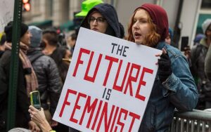 Woman holding a sign that says "The Future is Feminist"