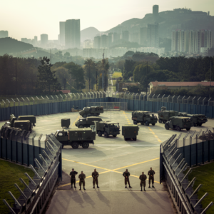 Soliders and military vehicles outside of a city.